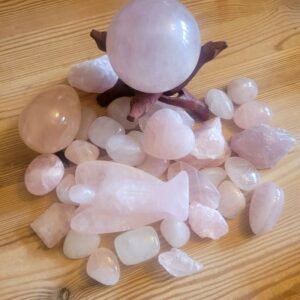 a collection of rose quarts in hues from almost white to pink. Sphere, egg, angel crystals and tumbled stones.